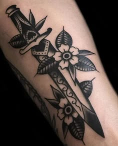 a black and white photo of a cross with flowers on it's side arm