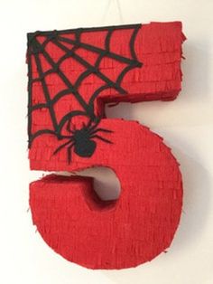 the number five is made out of yarn and has a spider on it's face