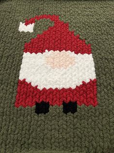 a crocheted santa clause blanket on top of a bed