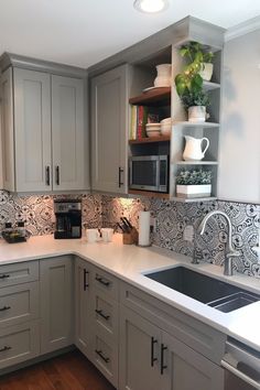 a kitchen with gray cabinets and white counter tops, an oven, microwave and dishwasher