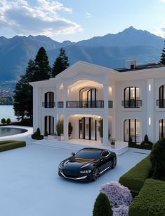 a black car parked in front of a large white house with mountains in the background