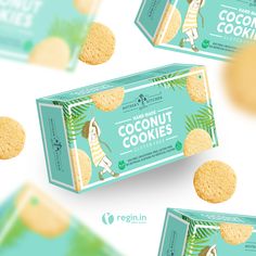 three boxes of coconut cookies on a white surface with palm leaves around them and the box is open