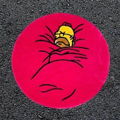 a red round with a cartoon character on it's face in the middle of pavement