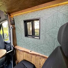 the interior of a vehicle with wood paneling and green wallpaper on the walls