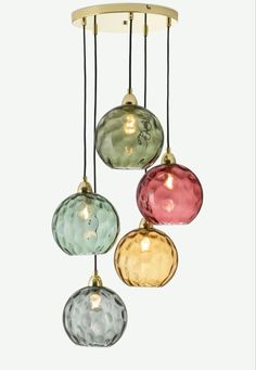 three multicolored glass balls hanging from a ceiling fixture with gold trimmings