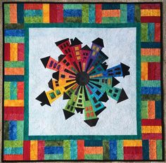 a multicolored quilt with a circular design on it's center and sides