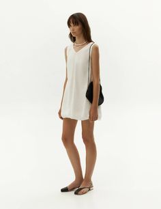 Elevate your wardrobe with our exquisite white balloon dress, crafted from premium viscose fabric that showcases a distinctive crinkled texture. Embracing a fashion-forward approach, this dress showcases a flattering v-neckline and a sleeveless silhouette, while its chic shorter length ensures suitability for any event. The timeless black hue exudes versatility, enabling effortless styling and making it an essential piece for your ensemble. Complete the look by pairing it with our faux-leather j Chic V-neck Dress With Crinkle Texture, Chic Crinkle Texture Dresses For Vacation, Chic Vacation Dresses With Crinkle Texture, Chic V-neck Viscose Dress For Summer, V-neck Crinkle Texture Summer Dress, V-neck Summer Dress With Crinkle Texture, Chic Crinkle Texture Dress For Daywear, Summer V-neck Dress With Crinkle Texture, Viscose V-neck Mini Dress For Daywear