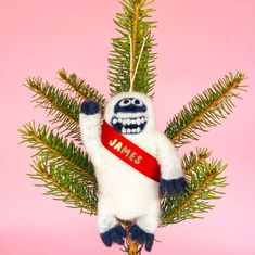 a white stuffed animal hanging from a christmas tree