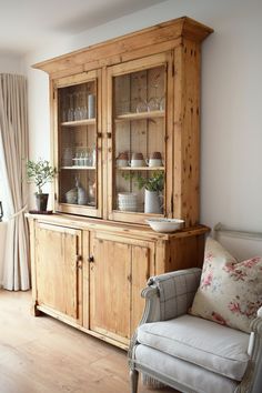 a wooden hutch with glass doors in a living room