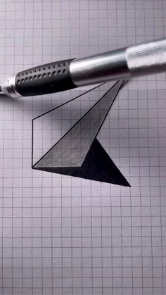 a pen is laying on top of a piece of graph paper with an origami bird