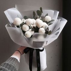 a person holding a bouquet of white flowers