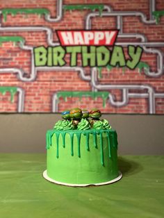 a green birthday cake sitting on top of a table