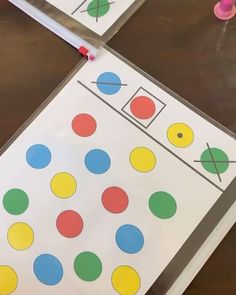 two pieces of paper with different colored dots on them and one piece cut out to look like a board game