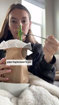 a woman is eating from a paper bag