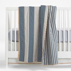 a baby crib with a blue and white striped blanket