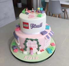 a birthday cake with lego friends on top