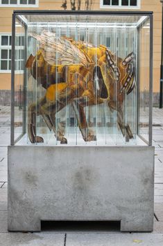 a glass case with a painting of a dog in it's cage on the sidewalk