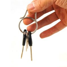 a hand holding two keys in each other's fingers