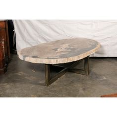 a table that is made out of wood and has a black iron base on it