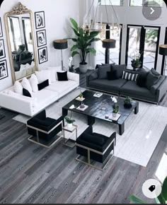 a living room filled with black and white furniture next to a large mirror on the wall