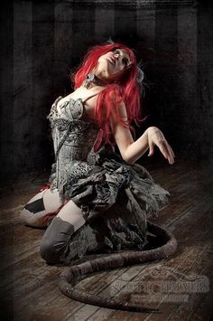 a woman with red hair sitting on the floor