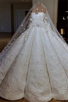 the back of a wedding dress with a veil on it's head and neck