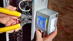 two people are working on an electrical panel