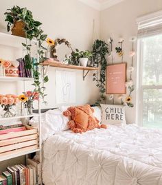 a white bed sitting next to a window with lots of books on top of it