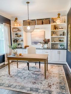 a dining room table and chairs in front of a bookcase with open shelving