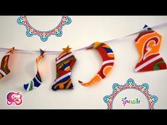 colorful paper letters are hanging from a string on a white wall and decorated with ornaments