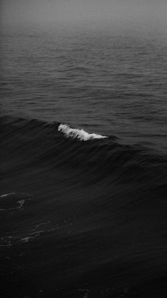 a black and white photo of a wave in the ocean