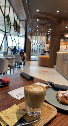 a cup of coffee sitting on top of a wooden table