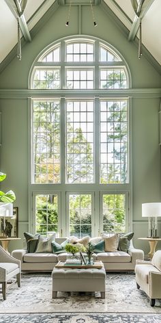 a living room filled with lots of furniture next to a large window covered in windows