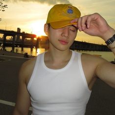 a man wearing a yellow hat and white tank top