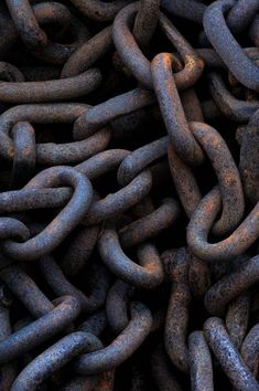 many rusty chains are stacked together to form a large chain that looks like it has been placed