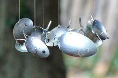 a metal bird mobile hanging from a tree