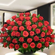 a vase filled with red roses on top of a table