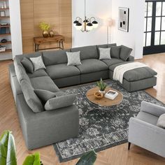 a living room filled with furniture and a large rug on top of a hard wood floor