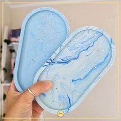 a hand holding up a blue and white soap dish