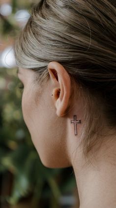 a woman with a cross tattoo on her left ear