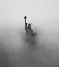 the statue of liberty is surrounded by fog