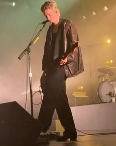 a man standing on top of a stage next to a microphone