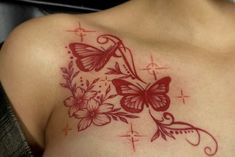 a close up of a woman's chest with butterflies and flowers tattooed on it