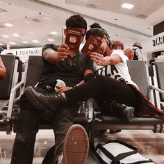 two people sitting in an airport reading books