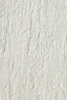 a white stucco wall with small cracks in it