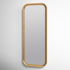 a gold framed mirror hanging on the wall