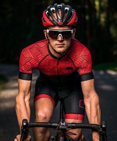 a man riding on the back of a bike down a road with trees in the background