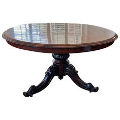 an oval wooden table with two leaves on the top and one leaf at the base