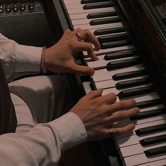 a man is playing the piano with his hands and fingers on it's keyboard