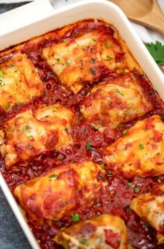 a casserole dish with meat and sauce in it, garnished with parsley